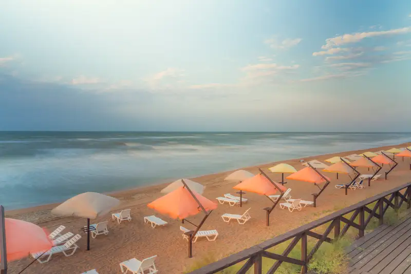 Пляж оборудованный зонтами и шезлонгами
