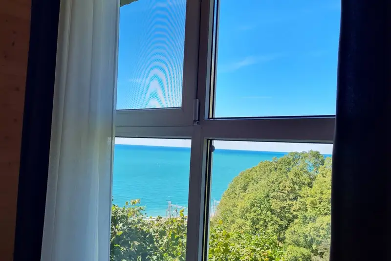 Панорамное окно с видом на море в двухкомнатном домике